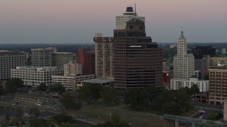 DX0002_181_030 - 5.7K aerial stock footage flying by and office high-rise at sunset in Downtown Memphis, Tennessee