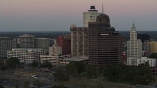 DX0002_181_031 - 5.7K aerial stock footage flying by office tower and apartment high-rise at sunset in Downtown Memphis, Tennessee
