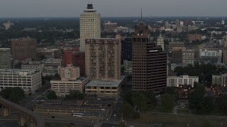 DX0002_181_032 - 5.7K aerial stock footage passing by apartment high-rise and office tower at sunset in Downtown Memphis, Tennessee