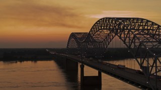 DX0002_181_043 - 5.7K aerial stock footage flying beside the Hernando de Soto Bridge at sunset, Downtown Memphis, Tennessee