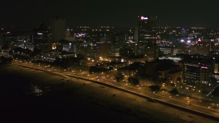 DX0002_182_013 - 5.7K aerial stock footage approach downtown office buildings and tilt to city street at night, Downtown Memphis, Tennessee