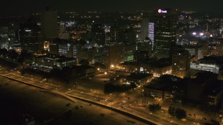 DX0002_182_014 - 5.7K aerial stock footage flying by downtown office buildings and city street at night, Downtown Memphis, Tennessee
