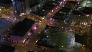 DX0002_182_046 - 5.7K aerial stock footage ascend away from intersection of Beale Street and BB King Boulevard at night in Downtown Memphis, Tennessee