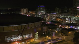 DX0002_182_050 - 5.7K aerial stock footage stationary view of FedEx Forum and Beale Street clubs at night in Downtown Memphis, Tennessee