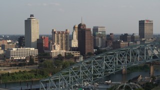 DX0002_185_021 - 5.7K aerial stock footage of the skyline seen while flying by the bridge at sunset, Downtown Memphis, Tennessee