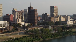 DX0002_185_026 - 5.7K aerial stock footage of Raymond James Tower and city buildings at sunset, Downtown Memphis, Tennessee