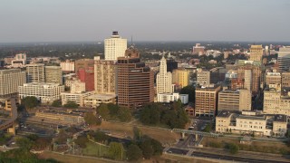 DX0002_186_002 - 5.7K aerial stock footage orbit and fly away from downtown buildings at sunset, Downtown Memphis, Tennessee