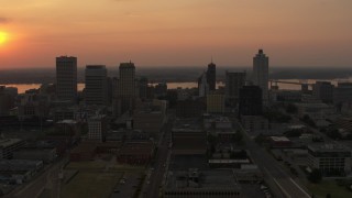 DX0002_186_025 - 5.7K aerial stock footage orbit the city skyline and reveal setting sun, Downtown Memphis, Tennessee