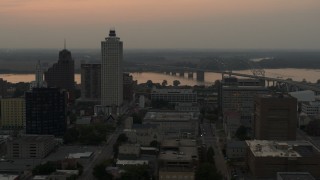 DX0002_186_040 - 5.7K aerial stock footage of office towers at sunset, with river and bridge in background, Downtown Memphis, Tennessee