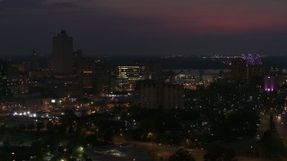 DX0002_187_027 - 5.7K aerial stock footage orbit city buildings between office tower and bridge at night, Downtown Memphis, Tennessee