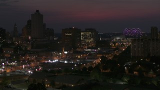 DX0002_187_028 - 5.7K aerial stock footage of city buildings between office tower and bridge at night, Downtown Memphis, Tennessee, seen during descent