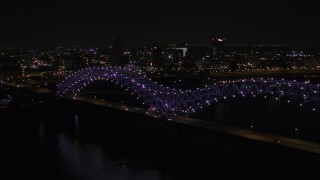 DX0002_187_033 - 5.7K aerial stock footage a stationary view of the bridge with purple lights and the Downtown Memphis skyline, Tennessee