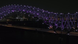 DX0002_187_036 - 5.7K aerial stock footage of passing the bridge with purple lights and a view of the skyline at night, Downtown Memphis, Tennessee