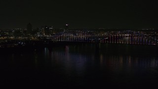 DX0002_187_043 - 5.7K aerial stock footage stationary view of the skyline behind bridge with colorful lights at night, Downtown Memphis, Tennessee