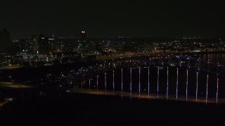 DX0002_187_048 - 5.7K aerial stock footage fly over the bridge with colorful lights toward skyline at night, Downtown Memphis, Tennessee