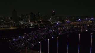 DX0002_187_049 - 5.7K aerial stock footage of flying by the skyline at night and reveal the bridge, Downtown Memphis, Tennessee