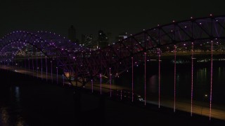 DX0002_187_052 - 5.7K aerial stock footage of flying by colorful lights on the bridge at night near Downtown Memphis, Tennessee