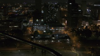 DX0002_187_065 - 5.7K aerial stock footage approaching apartment high-rise and parking garage at night, Downtown Memphis, Tennessee