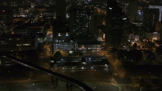 DX0002_187_066 - 5.7K aerial stock footage reverse view of apartment high-rise and parking garage at night, Downtown Memphis, Tennessee