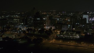DX0002_187_068 - 5.7K aerial stock footage orbiting downtown buildings by office high-rise at nighttime, Downtown Memphis, Tennessee