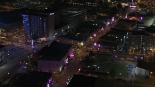 DX0002_188_006 - 5.7K aerial stock footage of bright lights and signs down Beale Street at nighttime, Downtown Memphis, Tennessee