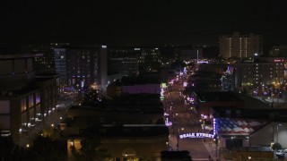 DX0002_188_018 - 5.7K aerial stock footage of flying past busy Beale Street at nighttime, Downtown Memphis, Tennessee