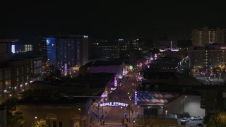 DX0002_188_019 - 5.7K aerial stock footage of passing by busy Beale Street at nighttime, Downtown Memphis, Tennessee