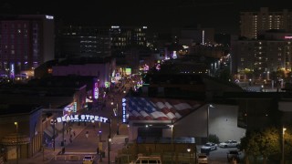 DX0002_188_033 - 5.7K aerial stock footage of passing the Beale Street sign at nighttime, Downtown Memphis, Tennessee