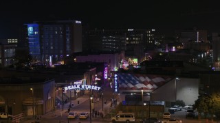 DX0002_188_040 - 5.7K aerial stock footage of passing the Beale Street sign for view of clubs and restaurants at nighttime, Downtown Memphis, Tennessee