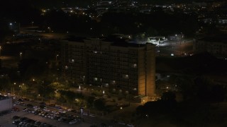 DX0002_188_043 - 5.7K aerial stock footage of flying away from, then orbiting an office building at nighttime, Memphis, Tennessee