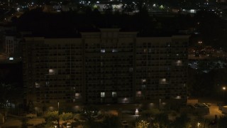 DX0002_188_044 - 5.7K aerial stock footage of descending by an office building at nighttime, Memphis, Tennessee