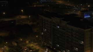 DX0002_188_046 - 5.7K aerial stock footage ascend by an office building at nighttime, Memphis, Tennessee