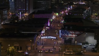 DX0002_188_048 - 5.7K aerial stock footage ascend while focused on the Beale Street sign near clubs and restaurants at nighttime, Downtown Memphis, Tennessee