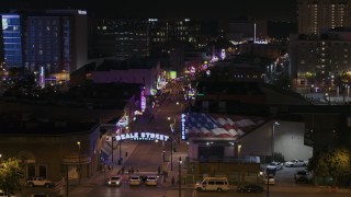 DX0002_188_049 - 5.7K aerial stock footage descend to reveal the Beale Street sign near clubs and restaurants at nighttime, Downtown Memphis, Tennessee