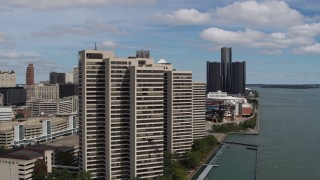 DX0002_189_010 - 5.7K aerial stock footage flyby apartment complex with skyscraper in the distance, Downtown Detroit, Michigan