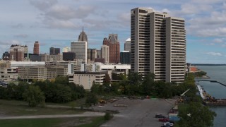 DX0002_189_024 - 5.7K aerial stock footage descend by apartment complex with view of skyline in Downtown Detroit, Michigan
