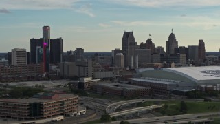 DX0002_191_039 - 5.7K aerial stock footage passing the football stadium, focus on the city skyline at sunset in Downtown Detroit, Michigan