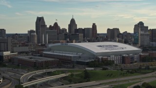 DX0002_191_041 - 5.7K aerial stock footage of a reverse view of the football stadium and the city skyline at sunset in Downtown Detroit, Michigan