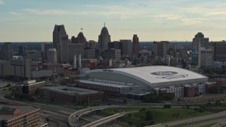 DX0002_191_042 - 5.7K aerial stock footage of slowly flying by the football stadium and the city skyline at sunset in Downtown Detroit, Michigan