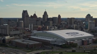 DX0002_191_043 - 5.7K aerial stock footage of slowly passing the football stadium and the city skyline at sunset in Downtown Detroit, Michigan