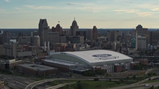 DX0002_191_046 - 5.7K aerial stock footage of Ford Field football stadium and the city skyline at sunset in Downtown Detroit, Michigan