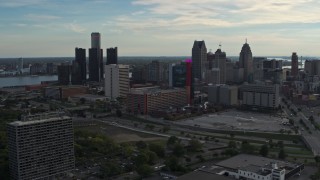 DX0002_192_008 - 5.7K aerial stock footage slowly flying by tall skyscrapers behind a hotel at sunset, Downtown Detroit, Michigan