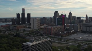 DX0002_192_009 - 5.7K aerial stock footage slowly passing tall skyscrapers behind a hotel at sunset, Downtown Detroit, Michigan