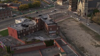 DX0002_192_015 - 5.7K aerial stock footage orbit an abandoned building at sunset, Detroit, Michigan