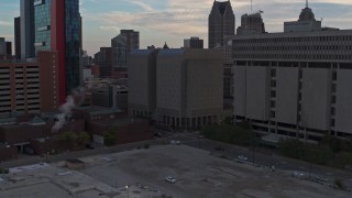 DX0002_192_032 - 5.7K aerial stock footage ascend while focusing on the Wayne County Jail Division 1 building at sunset, Downtown Detroit, Michigan