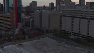 DX0002_192_033 - 5.7K aerial stock footage descend while focusing on the Wayne County Jail Division 1 building at sunset, Downtown Detroit, Michigan