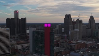 DX0002_192_034 - 5.7K aerial stock footage of flying by a hotel, skyscrapers in the background at sunset, Downtown Detroit, Michigan