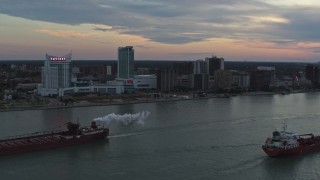 DX0002_192_046 - 5.7K aerial stock footage of the city skyline and oil tankers on the river, Windsor, Ontario, Canada, sunset