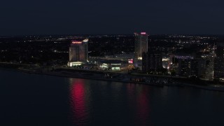 DX0002_193_011 - 5.7K aerial stock footage of Caesar Windsor hotel and casino across the river at night, Windsor, Ontario, Canada