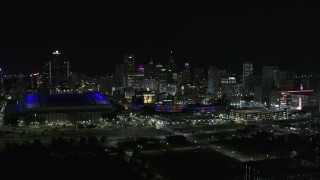 DX0002_193_047 - 5.7K aerial stock footage the skyline behind Ford Field and Comerica Park stadiums at night, Downtown Detroit, Michigan